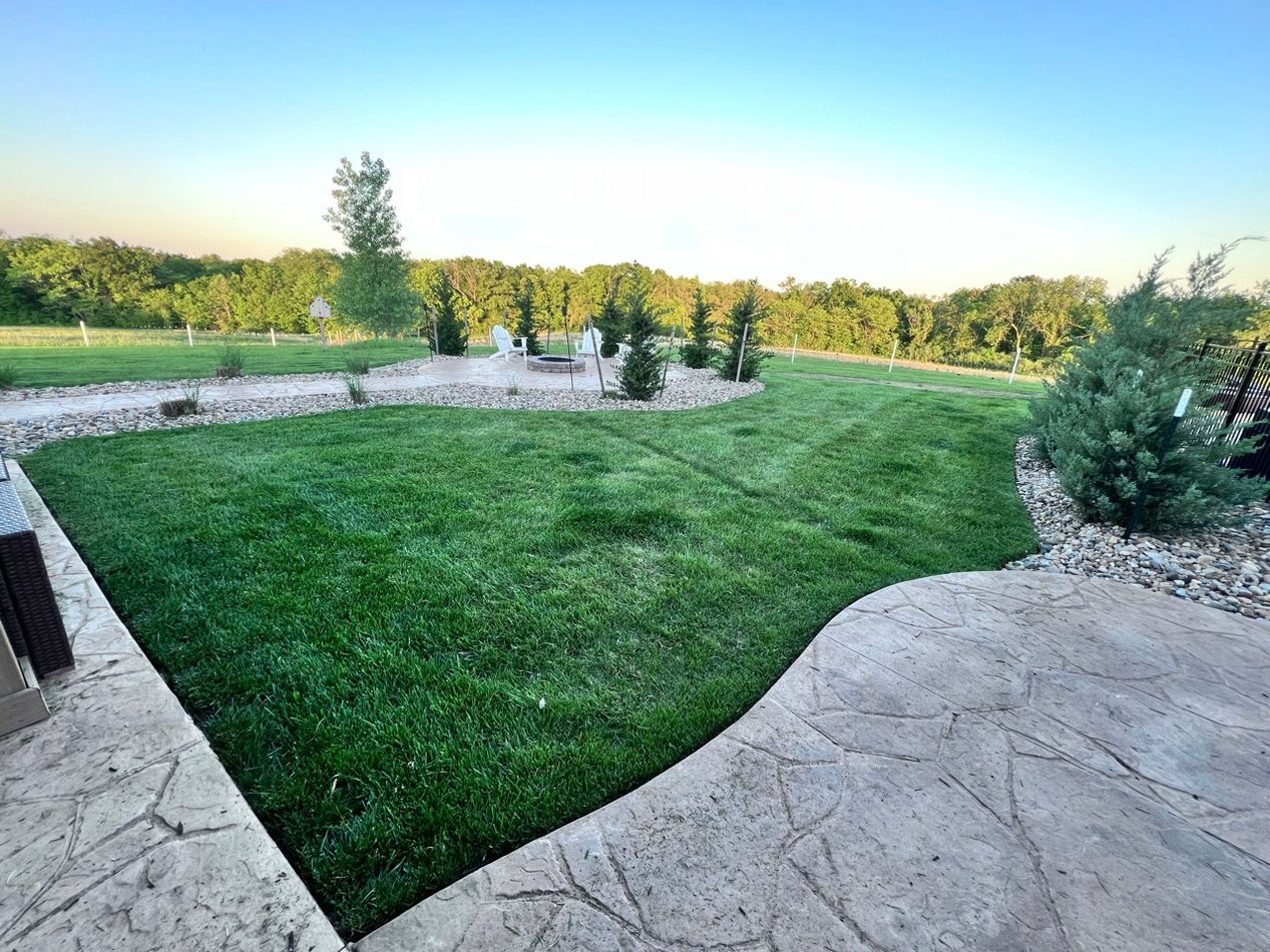 Maintained lawn with hardscape patio and landscape beds